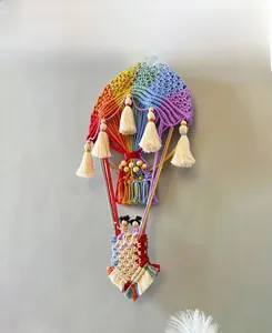 Detail der handgefertigten Makramee-Wanddekoration mit bunten Heißluftballons und Holzperlen