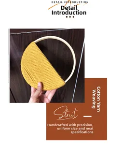 Detail of Bohemian handmade woven wall decor with yellow cotton thread and bamboo circle