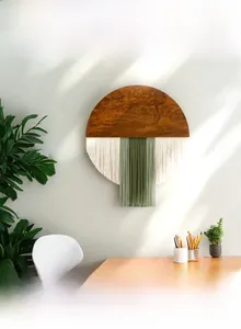 Details eines handgefertigten runden Wandteppichs mit Holz und grünen Quasten