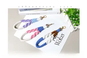 Macro view showing three colorful hand-woven braided lanyards with golden lobster clasps