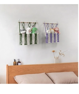 Detailed close-up of handmade bohemian woven toy hammocks with tassels and wooden rod