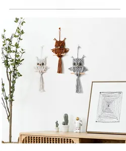 Detailed macro view of three handmade woven owl wall hangings in cotton and wood