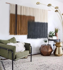 Detail of handmade macrame wall hanging with geometric weave and cotton fringe texture