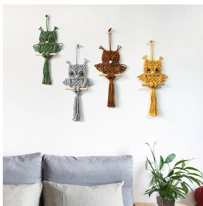 Detail showing four colorful macrame owl wall hangings with tassels in a cozy home setting