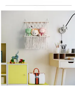 Detail of handmade macrame toy hammock featuring natural wood rods and cotton rope weave
