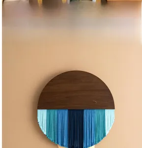 Detailansicht der runden Holzplatte und der blauen Baumwollquasten im Farbverlauf