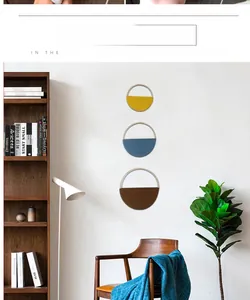 Detail of three minimalist woven round bamboo wall hangings in yellow, blue, and brown tones