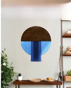 Detail der runden Wanddeko mit dunklem Holz und blauen Verlaufsfransen für Wohnzimmer