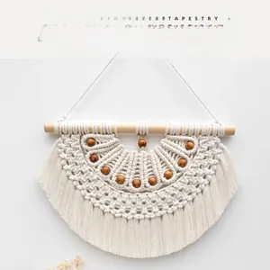 Detail of bohemian tassel tapestry with hand-woven cotton rope and wooden beads decor