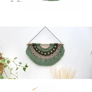 Close-up of bohemian woven tapestry with green and brown cotton fringe and wood beads