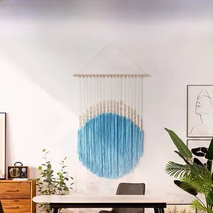 Detail of light blue handmade woven macrame wall hanging with wooden beads and fringes