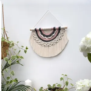 Macro detail of Bohemian woven wall hanging with cotton tassels and Morandi color scheme