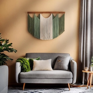 Detail of dark green and cream macramé wall hanging with tassels on a wooden rod