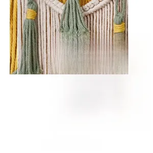 Detail of bohemian woven macrame wall hanging with handmade cotton tassels in green and yellow