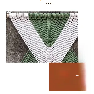 Dettaglio dell'arazzo macramè a V geometrico con corde di cotone verdi e bianco crema