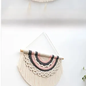Detail of bohemian rainbow cotton woven wall hanging with fringe and wooden rod