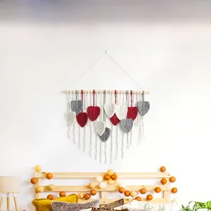 Close-up of handmade bohemian macrame leaf wall hanging with colorful cotton tassels