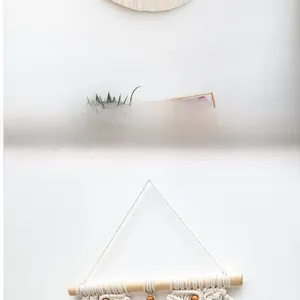 Detail of bohemian macrame wall hanging showing woven cotton ropes and wooden beads