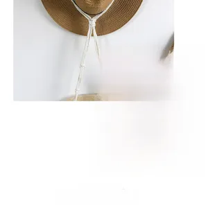 Detail view of woven straw hat featuring textured white cotton rope and artisan braiding