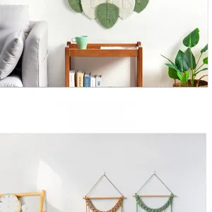 Détails d'une suspension murale en macramé avec feuilles et pompons de style boho