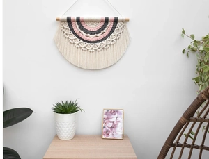 Detail of handmade bohemian rainbow tapestry featuring woven cotton and tassels