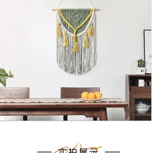 Detailed shot of handmade bohemian woven tapestry with yellow tassels and wood rod