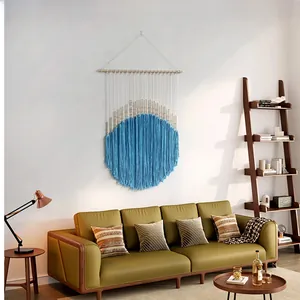Detail of bohemian woven tapestry featuring blue cotton fringe and round macrame beads