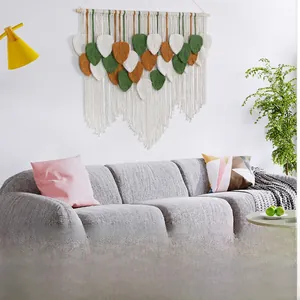 Detail of bohemian leaf-shaped macrame wall hanging with cotton cord and wood pole