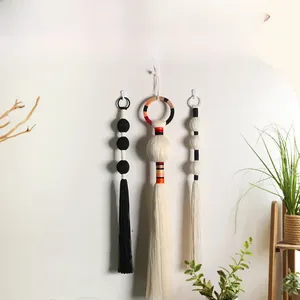 Detail of bohemian handmade woven wall hanging featuring cotton spheres and elegant tassels