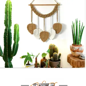 Détail d'une tapisserie murale en macramé avec feuilles de coton et perles en bois