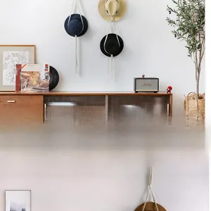 Detail of bohemian cotton rope hat organizer featuring navy, beige, and black straw hats