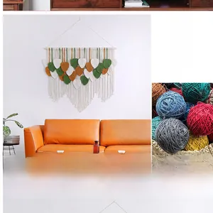Detail of handmade macrame leaf tapestry in green and brown tones on a warm wall