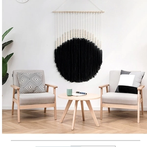 Detail of bohemian round black cotton fringe tapestry with wooden rod and beads decoration