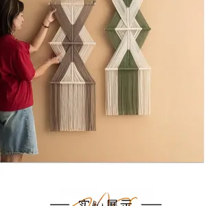 Dettaglio decorazione murale in macramè con nappe di cotone e asta di legno
