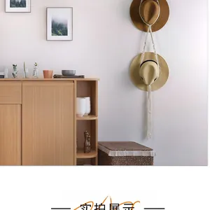 Detail showing bohemian woven hat storage rack with two straw hats on a clean white wall