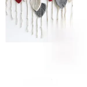 Detail of bohemian woven wall hanging featuring cotton leaf shapes and fringe tassels