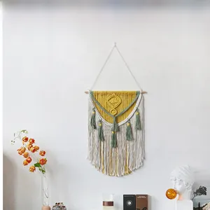 Detail showing the intricate bohemian macrame weaving textures and sage green fringe