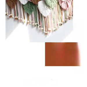 Detail of bohemian hand-woven macrame leaves with wooden beads on white wall