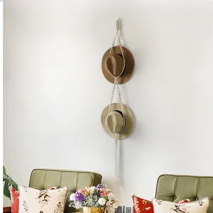 Detail of bohemian cotton woven wall hanging hat rack with fringes and hats