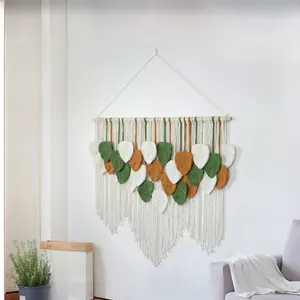 Close-up of handmade macrame leaves tapestry in green, orange and cream cotton rope
