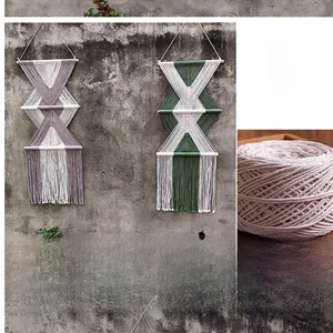 Dettaglio di un arazzo in macramé fatto a mano con trama geometrica e nappe di cotone