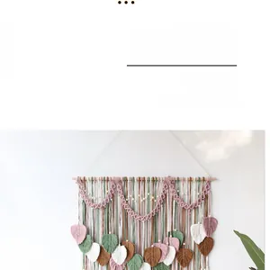 Close-up of handmade macrame leaf tapestry in sage green and pink on white wall