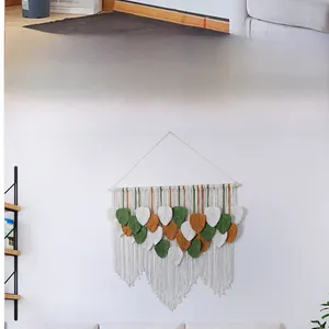 Detailed close-up of handmade macramé leaf wall hanging with cotton cord tassels