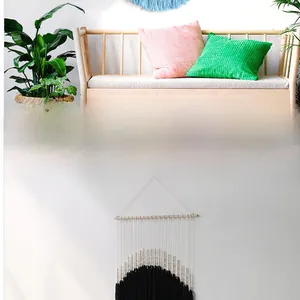 Detail of bohemian handmade cotton tapestry featuring black tassels and light wood beads
