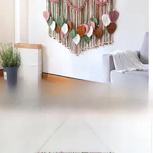 Detail of handmade macrame leaf wall hanging with colorful cotton threads and wooden beads