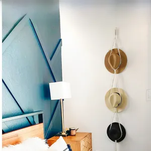 Detail of bohemian macrame hat organizer showing handmade woven cotton rope on blue wall