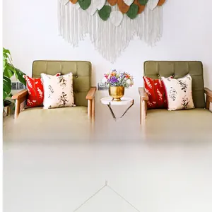 Detail of bohemian leaf tapestry with green and caramel tassels on a white wall