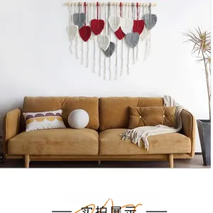 Detailed macro view of handmade macrame wall hanging with woven leaves in grey and burgundy