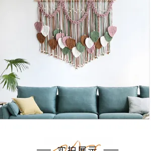 Detail of bohemian macrame wall hanging featuring colorful woven leaves and wooden beads