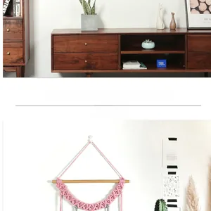 Gros plan sur une tapisserie murale en macramé rose faite main au motif de feuilles